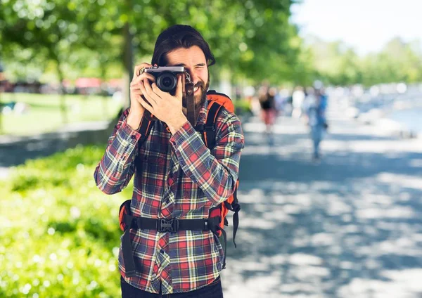 Duizendjarige backpacker met camera tegen wazig campus — Stockfoto