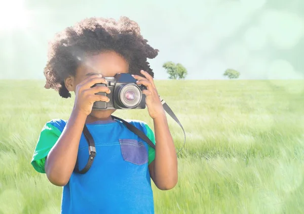 男孩与照相机反对草甸与火光 — 图库照片