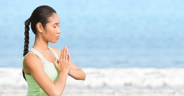 Mujer meditando contra el agua borrosa — Foto de Stock