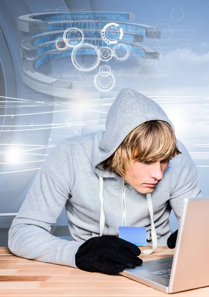 Hacker, der eine Kreditkarte hält, während er einen Laptop benutzt — Stockfoto