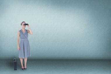 Mavi arka plan ve kopya alanı karşı dürbün ile arayan kadın 