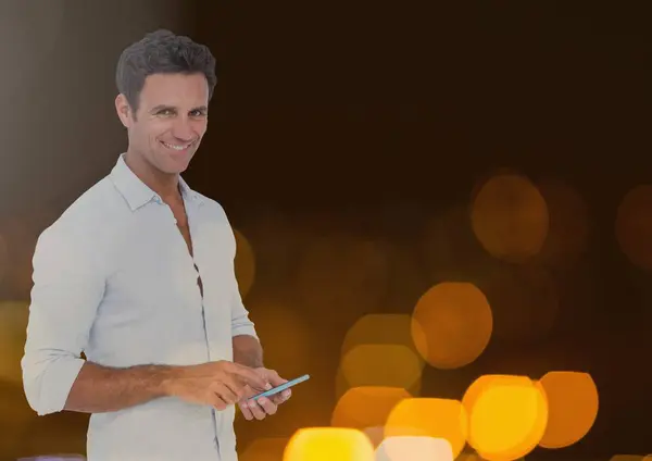 Usmívající se muž textových zpráv v světla — Stock fotografie