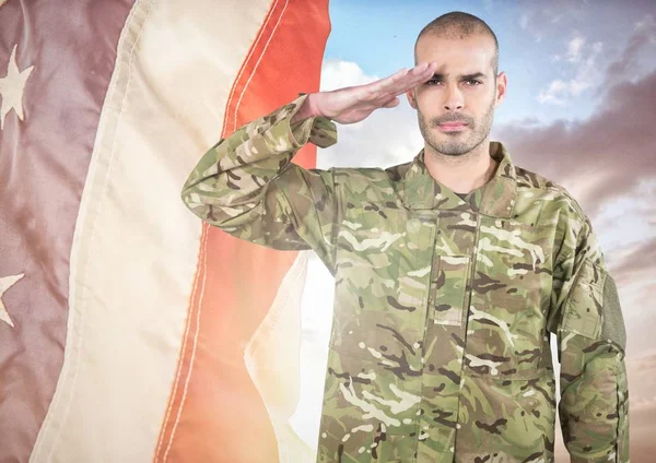Soldier saluting against a fluttering american flag — Stock Photo, Image
