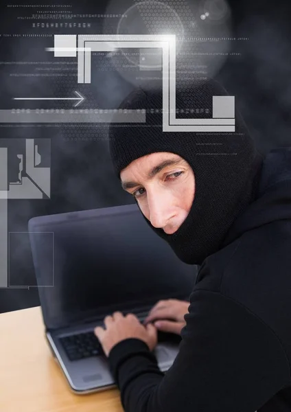 Hacker schaut in die Linse und benutzt einen Laptop — Stockfoto