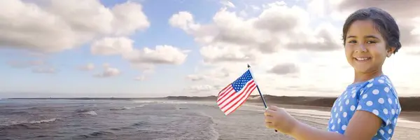Chica con bandera americana contra costa — Foto de Stock