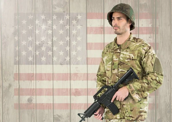 Żołnierz trzyma broń palna przed amerykańską flagę — Zdjęcie stockowe