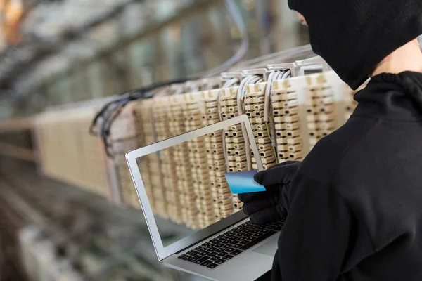 Hacker met behulp van een laptop in een datacenter — Stockfoto