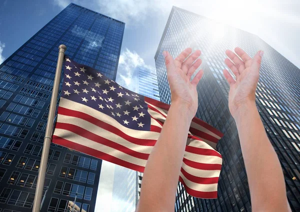 Arm gegen amerikanische Flagge und Wolkenkratzer erhoben — Stockfoto