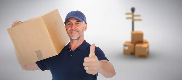 Kompositbild eines glücklichen Zustellers mit Karton, der Daumen nach oben zeigt — Stockfoto