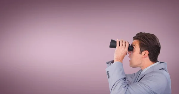 Förvånad man tittar genom kikaren mot rosa bakgrund — Stockfoto