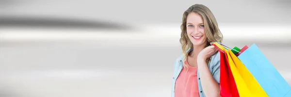 Shopper mit Taschen vor verschwommenem grauen abstrakten Hintergrund — Stockfoto