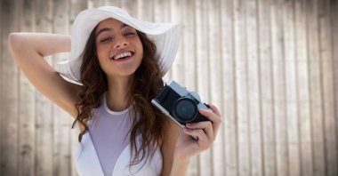 Bin yıllık kadın kamera karşısına bulanık ahşap panel ile yaz şapka