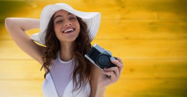 Bin yıllık kadın kamera karşısına bulanık sarı ahşap panel ile yaz şapka