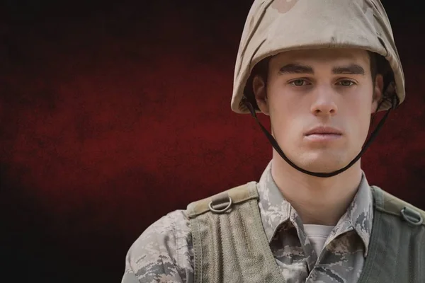 Soldat man står mot röd bakgrund — Stockfoto