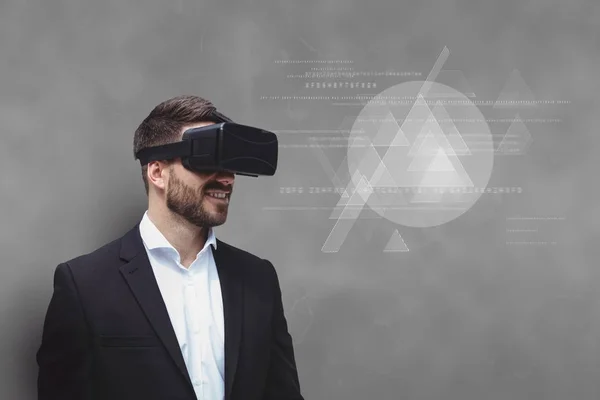 Людина в гарнітурі VR дивиться на інтерфейс на сірому фоні — стокове фото