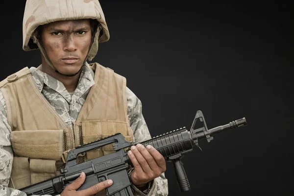 Angry soldier man holding a weapon against black background — Stock Photo, Image