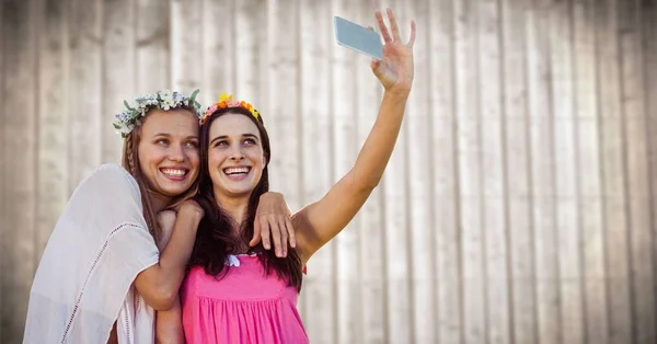 Hippie meninas tomando selfie contra painel de madeira embaçada — Fotografia de Stock