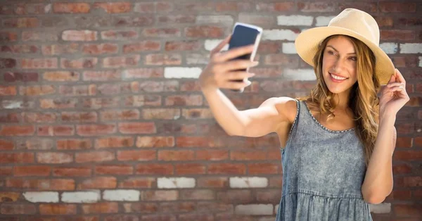 Mujer milenaria en ropa de verano tomando selfie contra la pared de ladrillo rojo —  Fotos de Stock