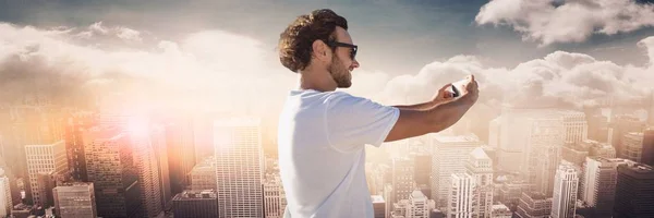 Muž bílé tričko s selfie proti Panorama s mraky — Stock fotografie