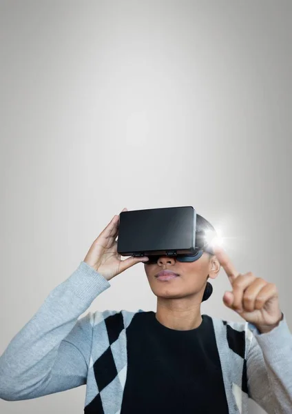 Mulher no fone de ouvido VR tocando um sinalizador contra fundo cinza — Fotografia de Stock
