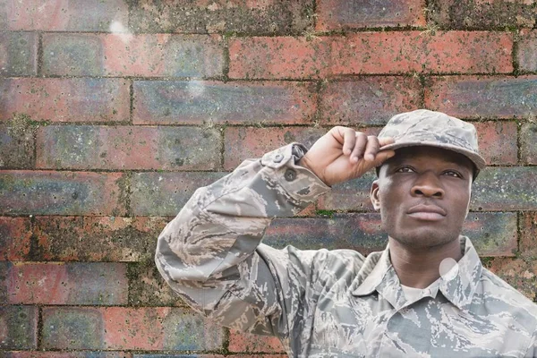 Soldat steht gegen Ziegelmauer — Stockfoto