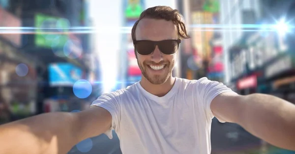 Man taking selfie against blurry street with flares and bokeh — Stock Photo, Image