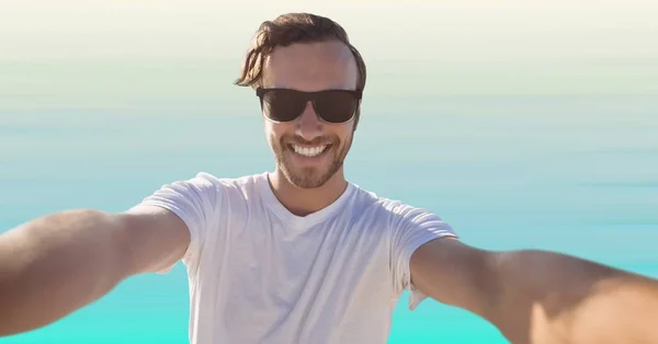 Man neemt selfie tegen lichte blauwe achtergrond — Stockfoto