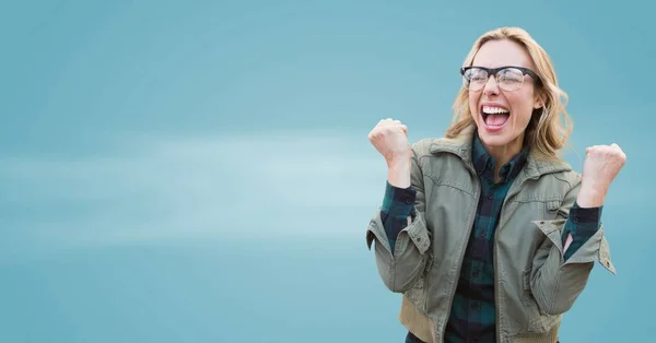 Mujer de abrigo celebrando contra fondo azul borroso —  Fotos de Stock