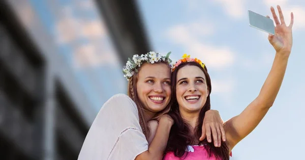 Hippie girls taking selfie against blurry building — Stock Photo, Image