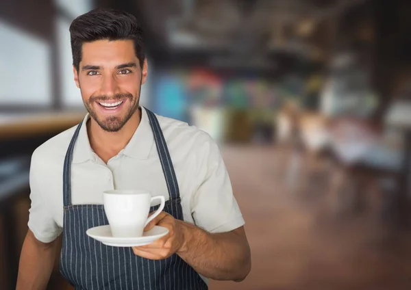 Власник кафе роздає чашку кави проти розмитого кафе — стокове фото