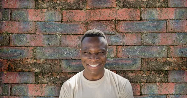 Człowiek szczęśliwy żołnierz stojący przed mur z cegły — Zdjęcie stockowe