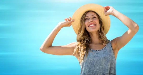 Kvinna i sommar hatt med händer upp mot suddiga blå bakgrund — Stockfoto
