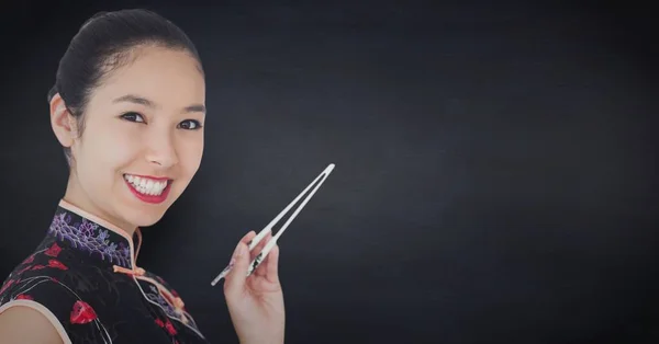 Close up of geisha with chopsticks against navy chalkboard Royalty Free Stock Images