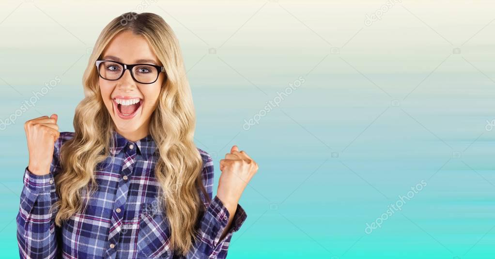Millennial woman celebrating against blurry blue background
