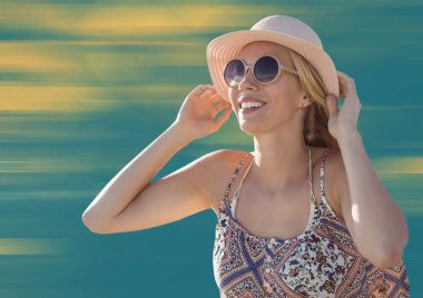 Kadın şapka ve güneş gözlüğü bulanık sarı ve mavi arka plan ile