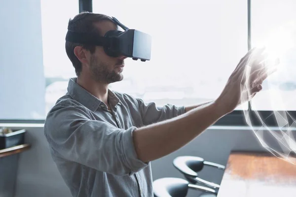 Homem no fone de ouvido VR tocando uma interface de esfera 3D — Fotografia de Stock