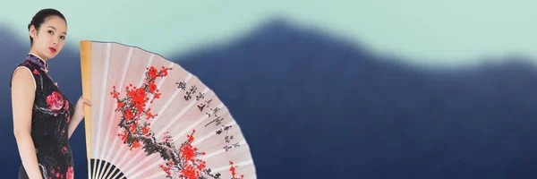 Geisha y ventilador gigante contra la montaña borrosa — Foto de Stock