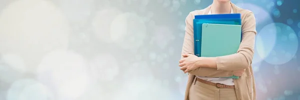 Woman holding files and folders with blurred sparkling background