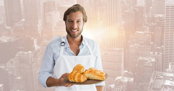 Restaurantbesitzer mit Croissants gegen verschwommene Skyline — Stockfoto