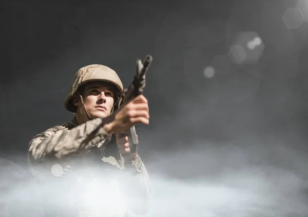 Soldado segurando uma arma contra fundo preto com nuvens e foguetes — Fotografia de Stock