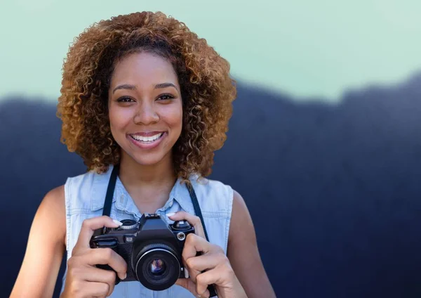 Millennial woman with camera against blurry mountain — Stock Photo, Image