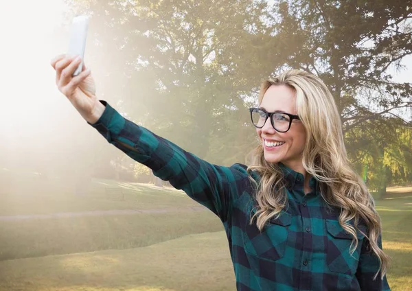 Duizendjarige vrouw selfie met wazige park met flare — Stockfoto
