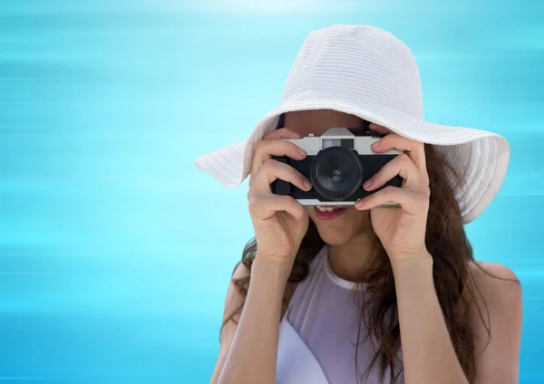 Duizendjarige vrouw in zomer hoed met camera tegen wazig blauwe achtergrond — Stockfoto