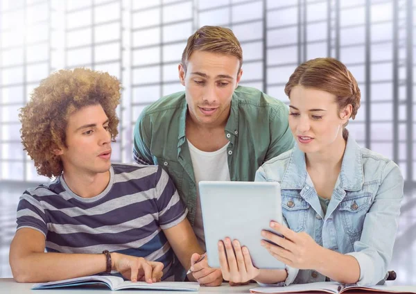Eleverna tittar på tablett framför suddig bakgrund — Stockfoto
