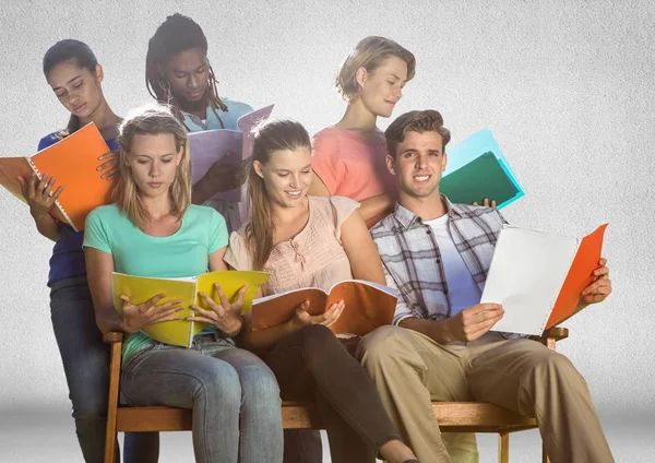 空白の灰色の背景の前に座って勉強している学生のグループ — ストック写真
