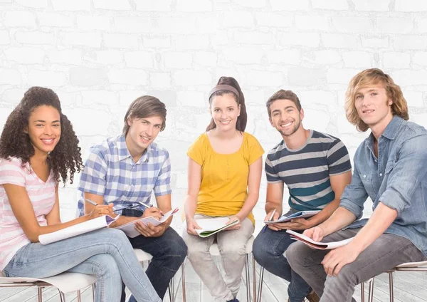 Grupo de estudantes sentados em frente ao fundo cinza tijolo — Fotografia de Stock