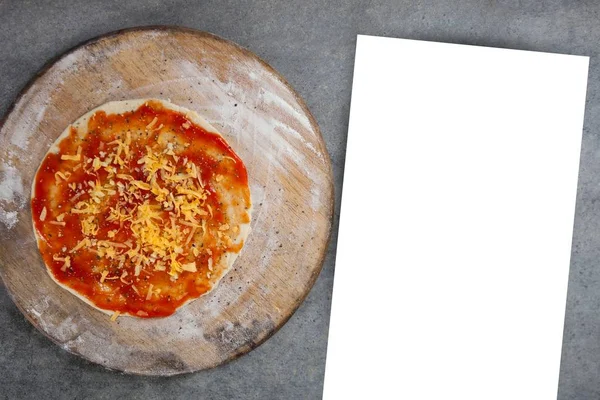 Papier op tafel naast pizza — Stockfoto