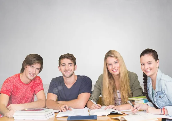 Grupo de estudiantes que trabajan y estudian frente al fondo gris — Foto de Stock