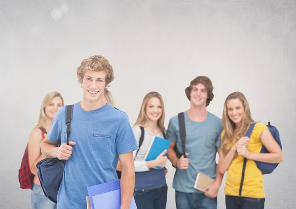 Grupo de estudiantes de pie frente a fondo gris en blanco — Foto de Stock
