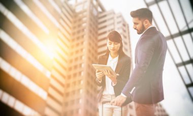 İş arkadaşları dijital tablet karşı modern ofis binası görünümünü kullanma